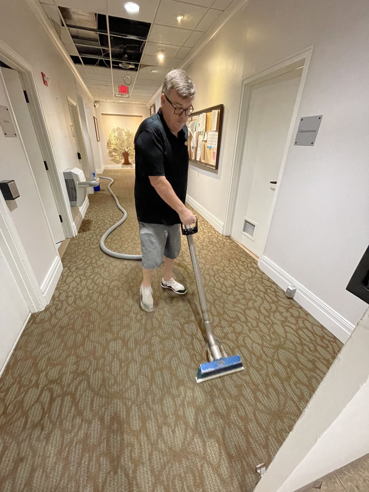Steve Hummel cleaning patterned commercial carpet in an office
hallway