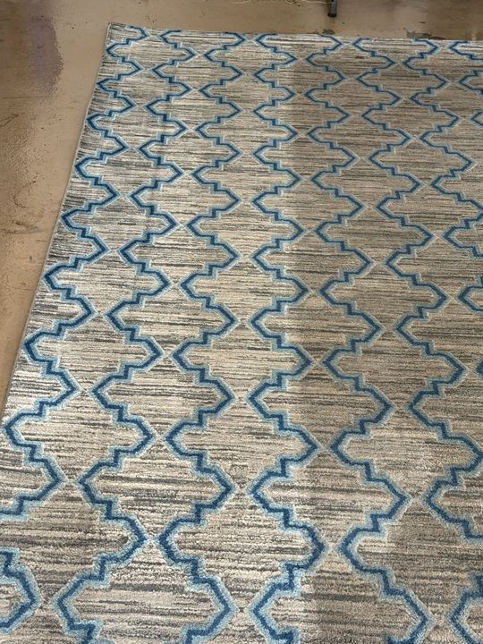 Blue and gray area rug with a clean section next to the dirty section