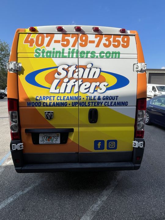 Back of the Stain Lifters van listing carpet, tile and grout, wood and upholstery cleaning