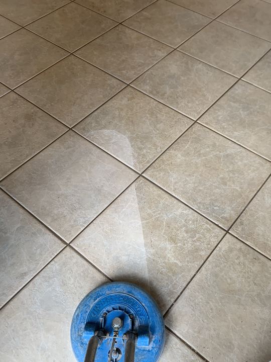 Spinning tile scrubber leaving a clean path across diagonal floor tile