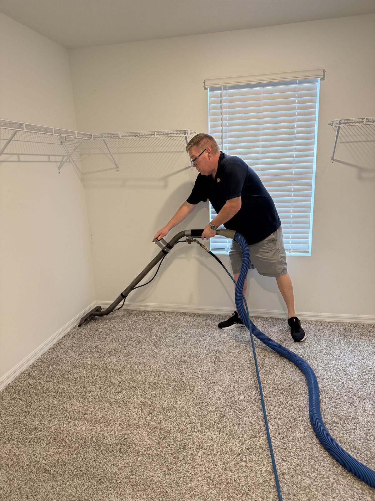 Owner Steve Hummel cleaning bedroom carpet with a truck-mount wand